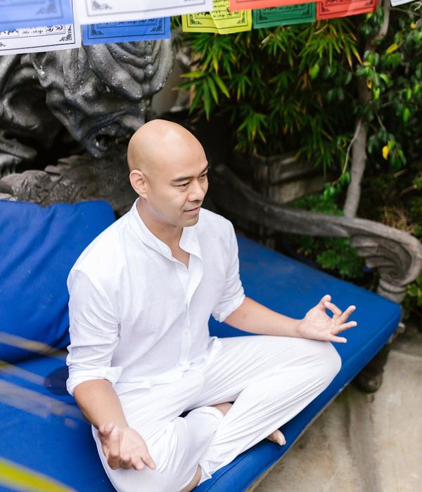 Man meditating peacefully in a natural outdoor setting.
